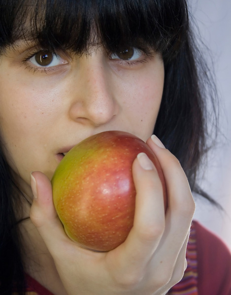 Девушка кушает яблоко